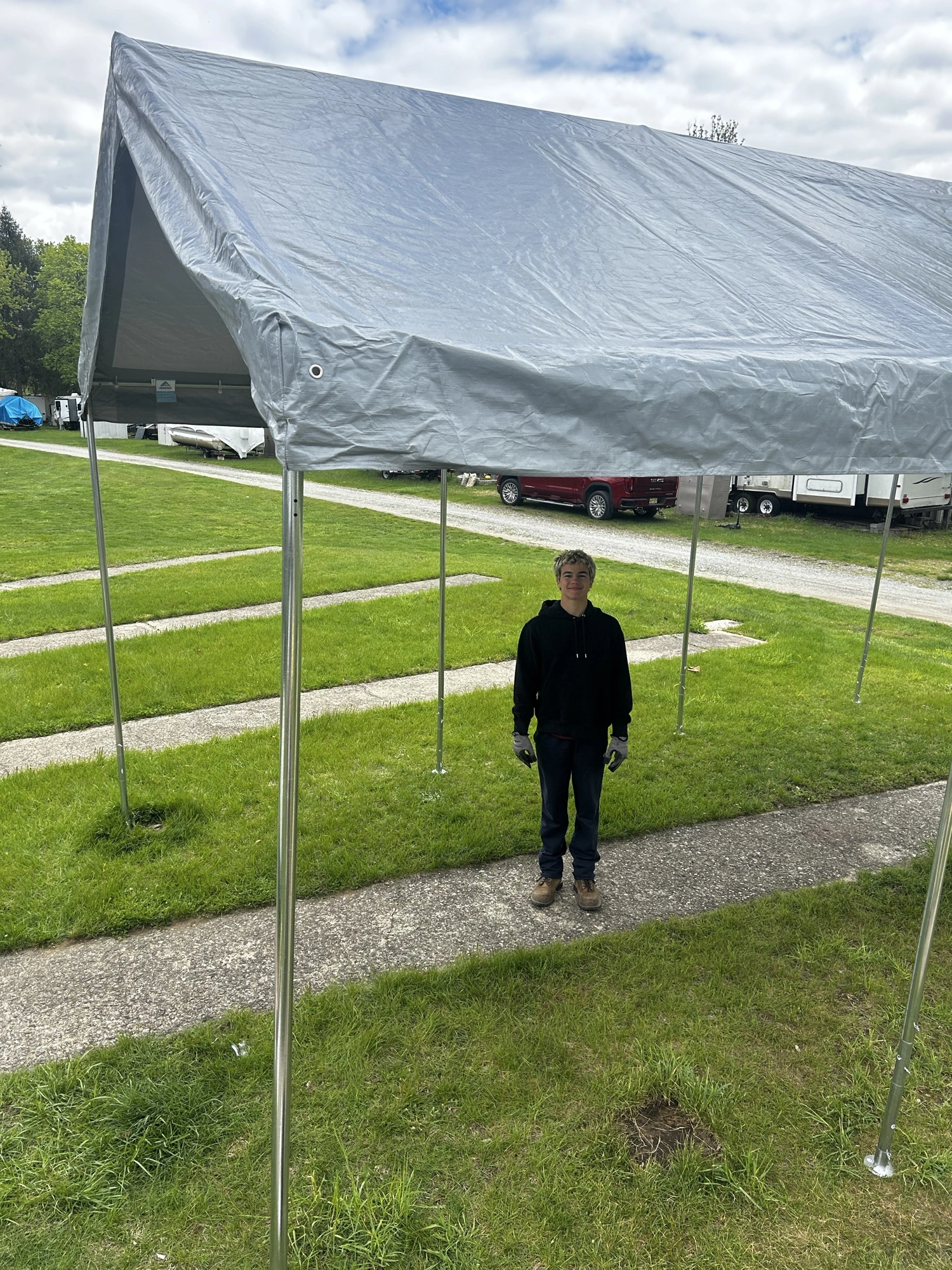 A crew member standing beneath an outdoor canopy